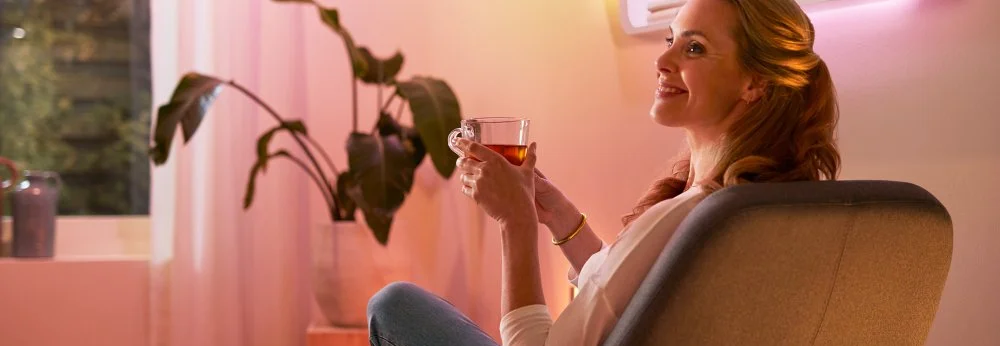 Person trinkt im Sessel sitzend Tee